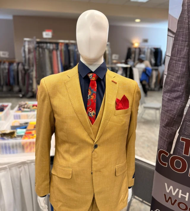 This bold gold 3-piece suit isn’t for blending in, it’s for the man who walks into the room and owns it. Paired with a deep navy shirt, a vibrant paisley tie, and a striking red pocket square, this look is all about confidence, style, and standing out for the right reasons.When our customers step in front of the mirror wearing something like this, that smile says it all.Come see us this weekend and discover the suit that turns heads before you even say a word.